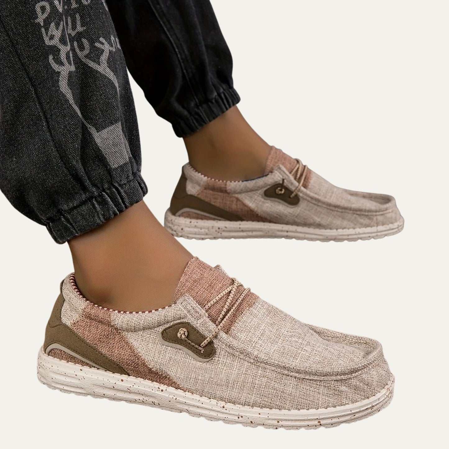 Beige canvas slip on loafers with a speckled rubber sole and a padded collar