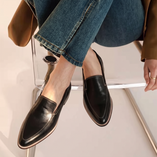Black leather slip on loafers with contrast stitching and a tan toned sole