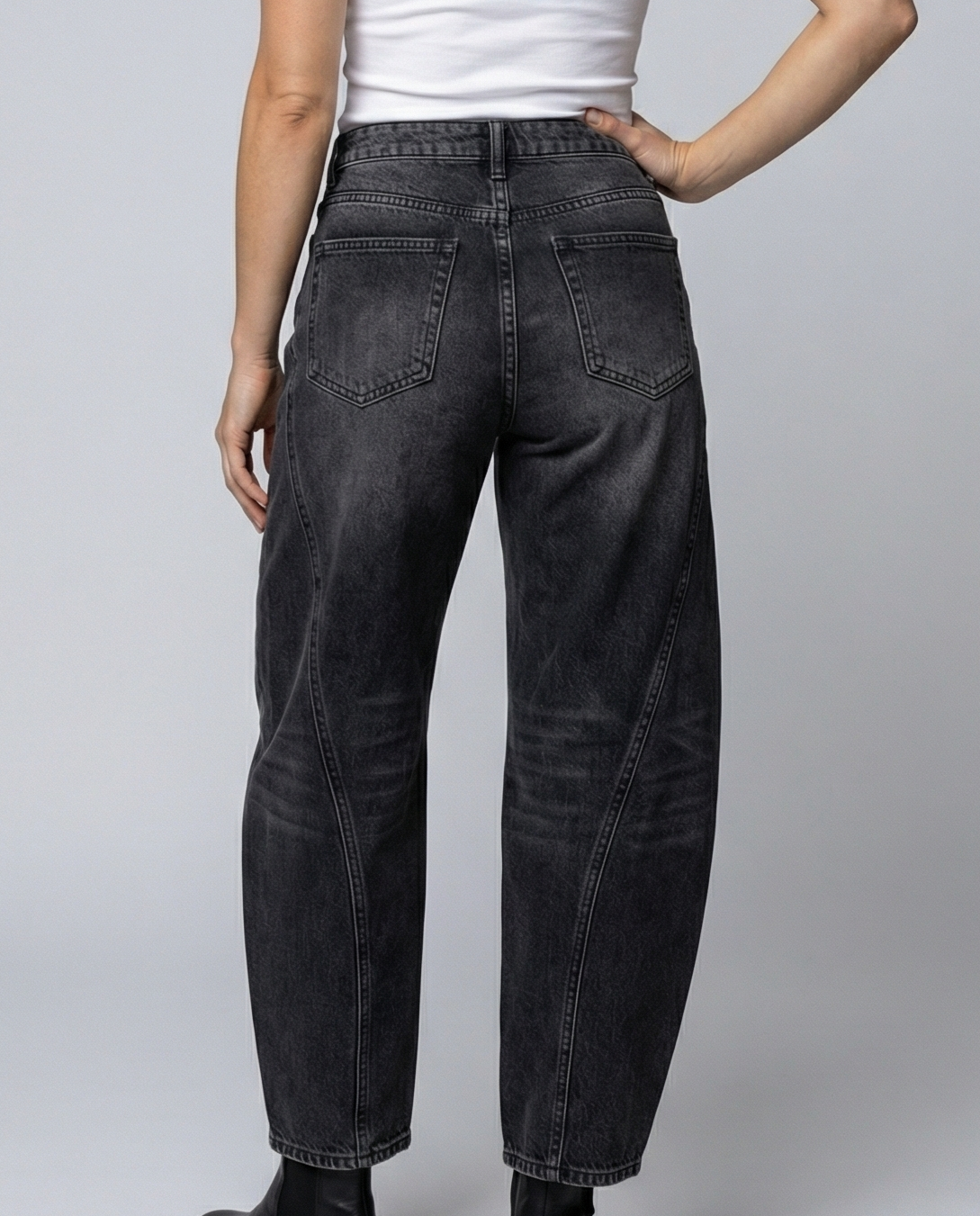 Blue barrel leg jeans with a mid rise waist and rounded slightly flared leg