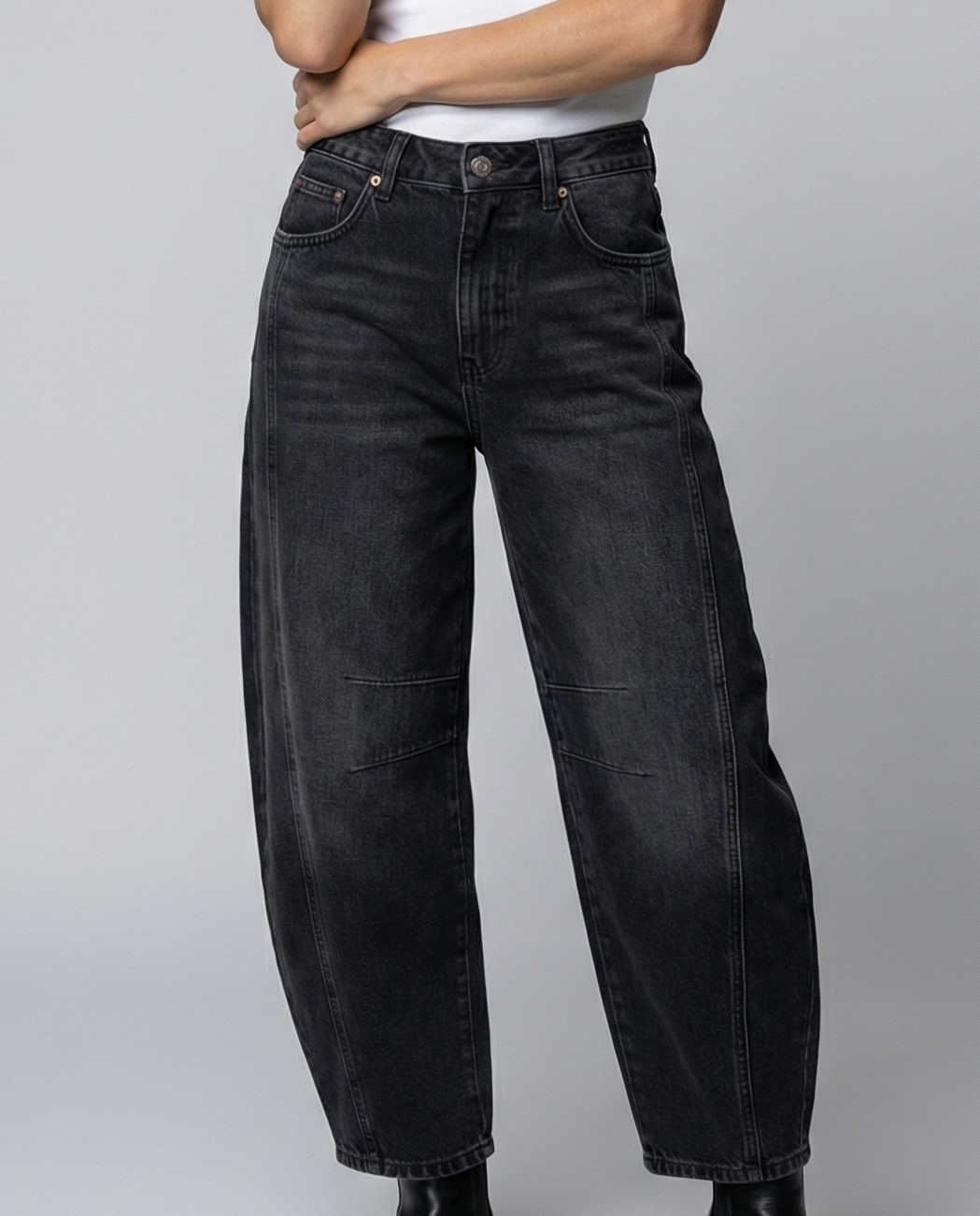 Blue barrel leg jeans with a mid rise waist and rounded slightly flared leg