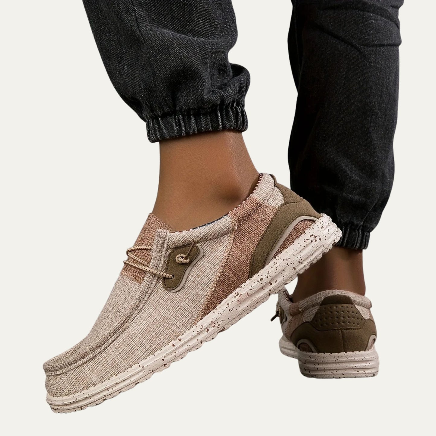Beige canvas slip on loafers with a speckled rubber sole and a padded collar