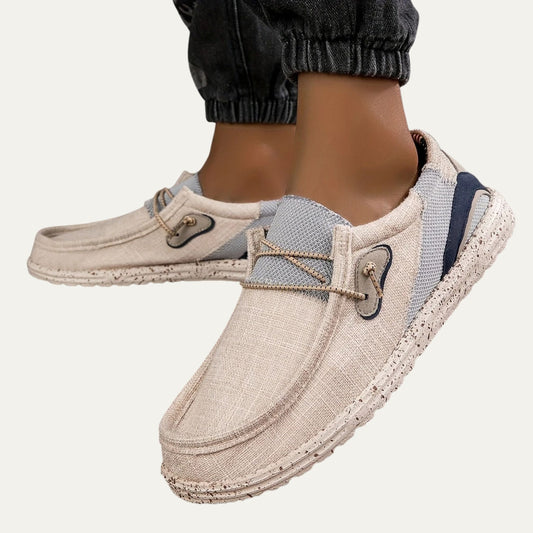 Beige canvas slip on loafers with a speckled rubber sole and a padded collar