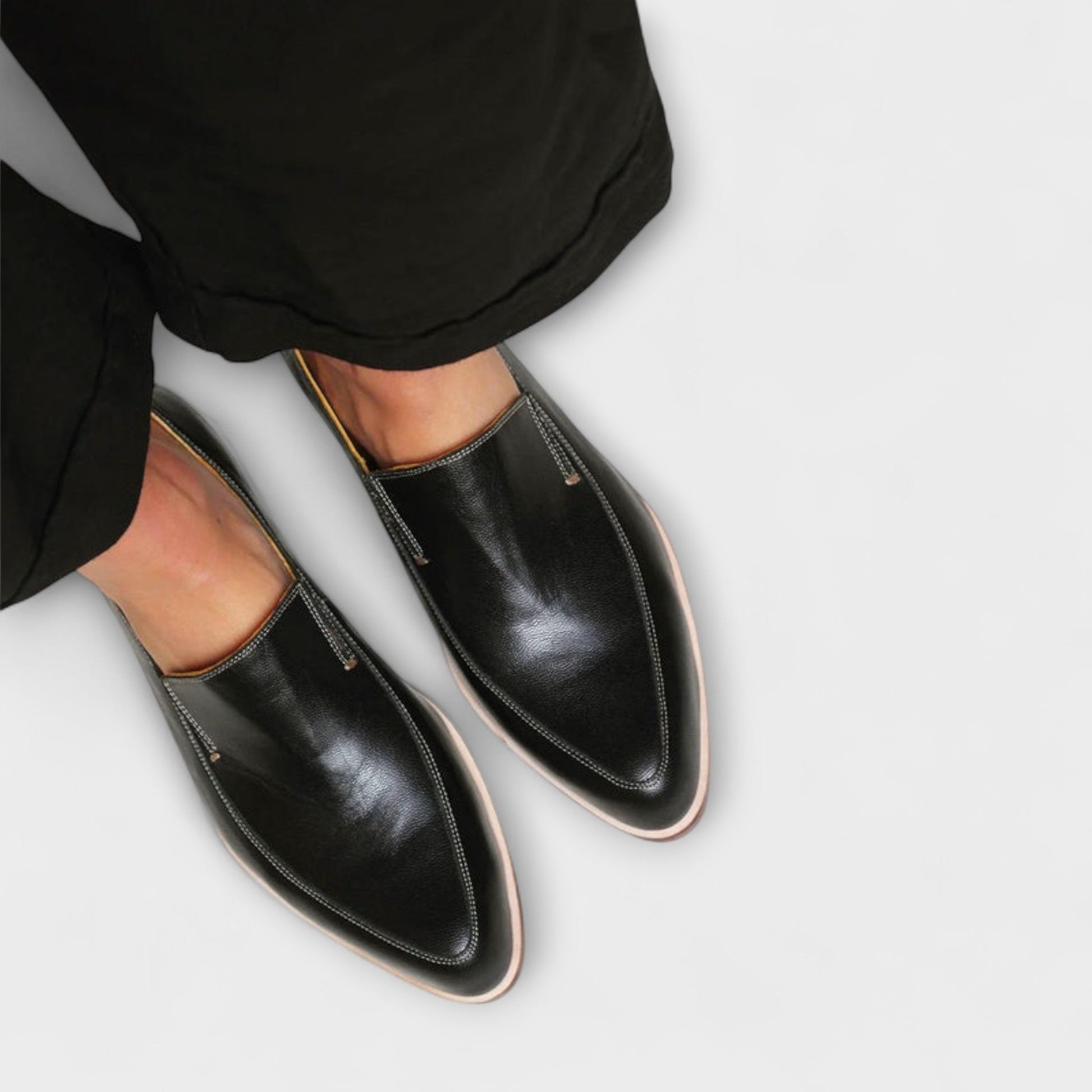 Black leather slip on loafers with contrast stitching and a tan toned sole