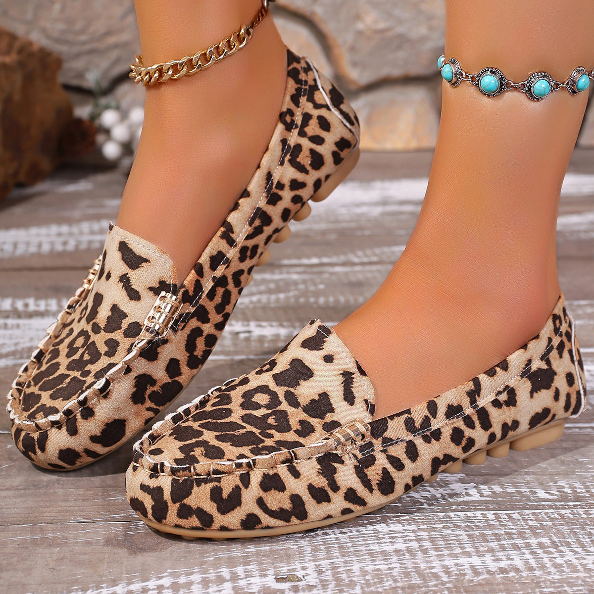 Brown leopard print moccasin loafers with decorative stitching and a studded sole