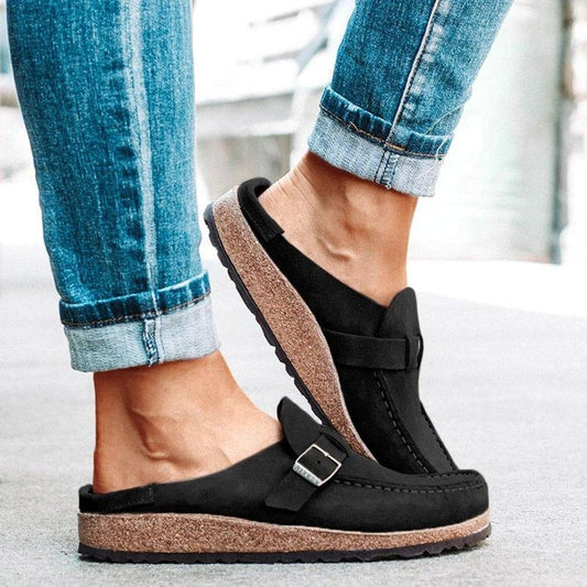 Khaki suede loafer mules with a buckle strap and a cork footbed