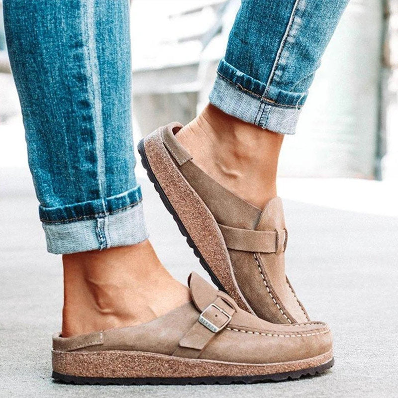 Khaki suede loafer mules with a buckle strap and a cork footbed