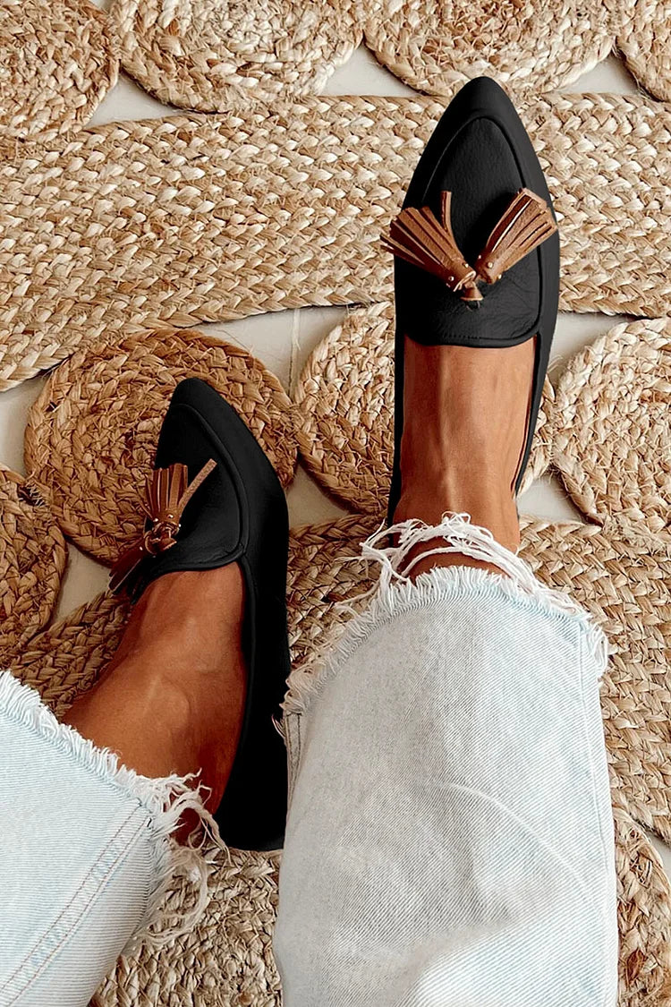 Black leather tassel loafers with cognac brown trim and metallic tassel detail